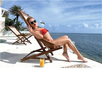 Blonde female posed wearing bathing suit lounging in lounge chair