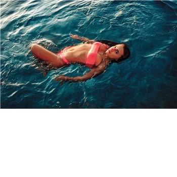 Brunette female posed lounging in water wearing bikini