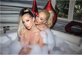 Two nude females in tub caressing