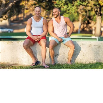 Two males posed seated wearing shorts and shirts