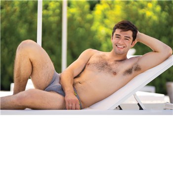 Topless male posed lounging wearing swim trunks