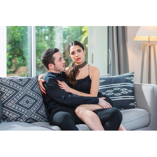 Clothed male caressing  clothed female on couch