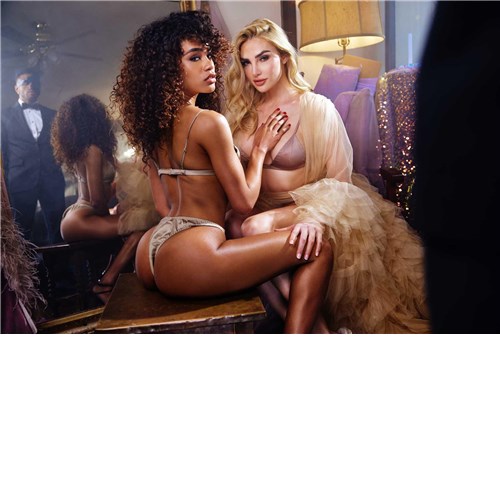 Brunette female wearing lingerie caressing blonde female wearing lingerie
