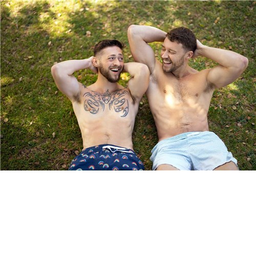 Two topless males posed lounging outdoors